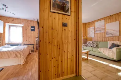 a room with wood paneled walls and a bedroom at Chalet Salejada - WiFi comfort and elegance in Moena