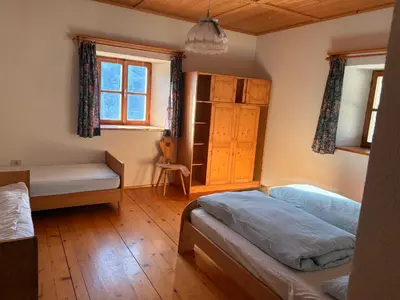 a bedroom with two beds and a bench and a window at Agriturismo Ciastel de Brach in Longega