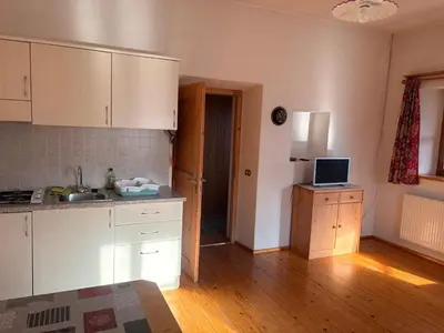 a kitchen with white cabinets and a laptop on a counter at Agriturismo Ciastel de Brach in Longega
