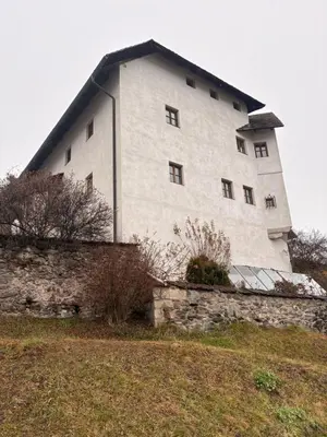 a large white building on top of a stone wall at Agriturismo Ciastel de Brach in Longega