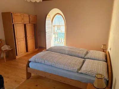 a bedroom with a bed with a large window at Agriturismo Ciastel de Brach in Longega