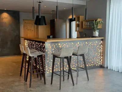 a kitchen with a counter with stools in a room at Premium Apartments Faselehof in Marlengo