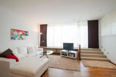 a living room with a white couch and a tv at Premium Apartments Faselehof in Marlengo