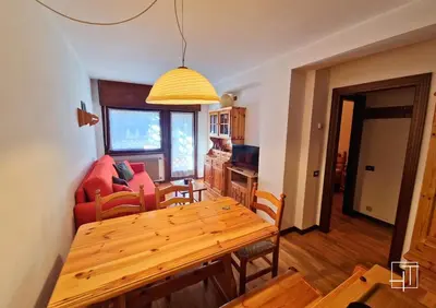 a dining room and living room with a wooden table at HT - Appartamento centrale nel cuore delle Dolomiti in San Vito di Cadore