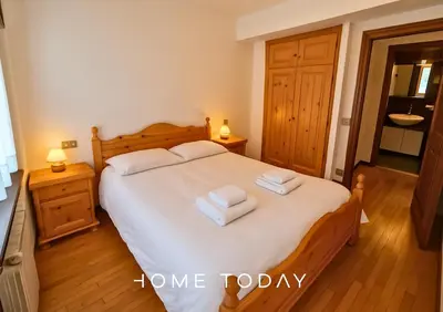 a bedroom with a large bed with towels on it at HT - Appartamento centrale nel cuore delle Dolomiti in San Vito di Cadore