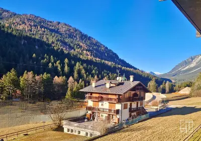 a building with a bunch of trash cans in a yard at HT - Appartamento centrale nel cuore delle Dolomiti in San Vito di Cadore