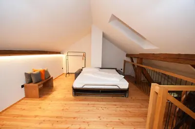 a attic room with a bed and a staircase at Aurturist Moar - San Lorenzo di Sebato in Floronzo