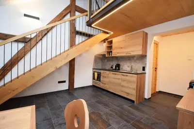 a kitchen with a staircase and wooden floors at Aurturist Moar - San Lorenzo di Sebato in Floronzo