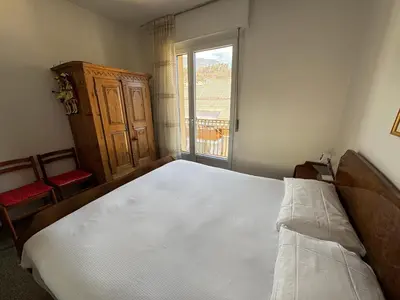 a bedroom with a large white bed and a window at A Due Passi dalle Piste in Cavalese