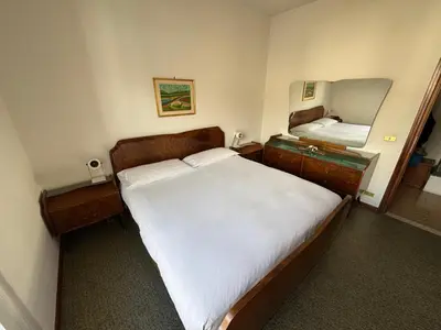 a bedroom with a large bed and a mirror at A Due Passi dalle Piste in Cavalese