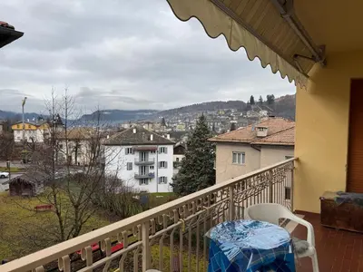 a balcony with a table and a view of a city at A Due Passi dalle Piste in Cavalese