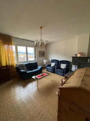a living room with two blue couches and a table at A Due Passi dalle Piste in Cavalese