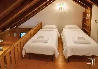 two beds in a room with a staircase at HT - Chalet panoramico con vista sulle Dolomiti in San Vito di Cadore