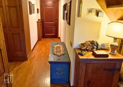 a hallway with a table and a lamp and a door at HT - Chalet panoramico con vista sulle Dolomiti in San Vito di Cadore