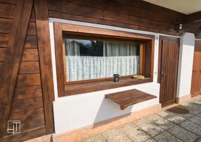 a wooden door with a window and a wooden bench at HT - Ciasa Ca' Novella nel cuore delle Dolomiti in San Vito di Cadore