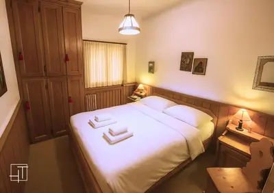 a bedroom with a bed with two white towels on it at HT - Ciasa Ca' Novella nel cuore delle Dolomiti in San Vito di Cadore