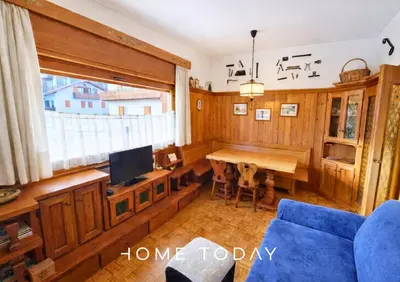 a living room with a blue couch and a table at HT - Ciasa Ca' Novella nel cuore delle Dolomiti in San Vito di Cadore