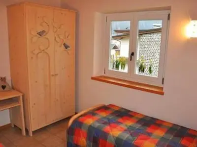 a bedroom with a bed and a window at Apartment Elegantes und geräumiges Dachgeschosszimmer in den Dolomiten by Interhome in Mezzano