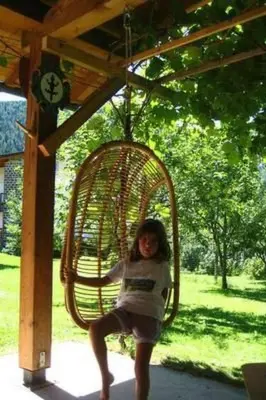 a young girl is sitting in a swing at Apartment Elegantes und geräumiges Dachgeschosszimmer in den Dolomiten by Interhome in Mezzano