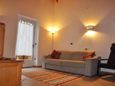 a living room with a couch and a window at Apartment Elegantes und geräumiges Dachgeschosszimmer in den Dolomiten by Interhome in Mezzano