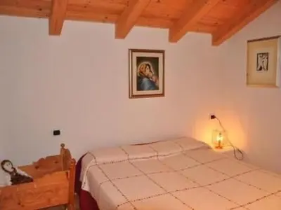 a bedroom with a bed and a lamp in it at Apartment Elegantes und geräumiges Dachgeschosszimmer in den Dolomiten by Interhome in Mezzano