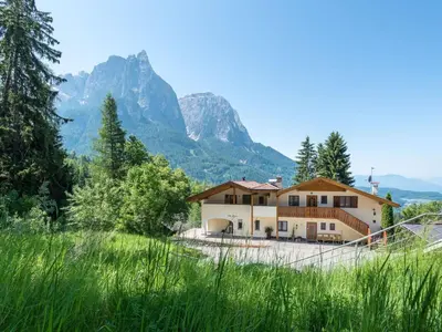 a house with a mountain in the background at Apartment mit traumhaftem Ausblick by Interhome in Siusi