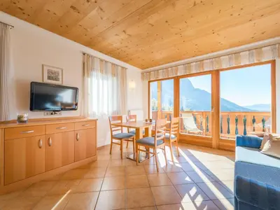 a living room with a table and chairs and a television at Apartment mit traumhaftem Ausblick by Interhome in Siusi