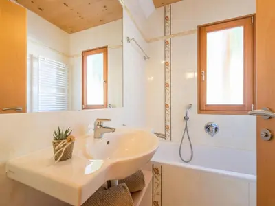 a bathroom with a sink and a tub and a mirror at Apartment mit traumhaftem Ausblick by Interhome in Siusi
