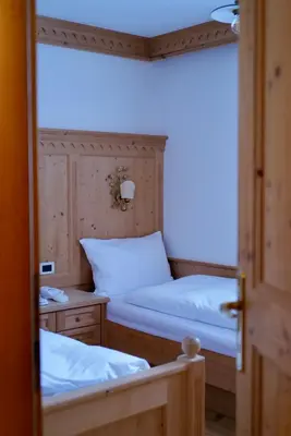 a room with two beds and a door open at Luxury Chalet at the Foot of the Dolomites by the Castle in La Villa