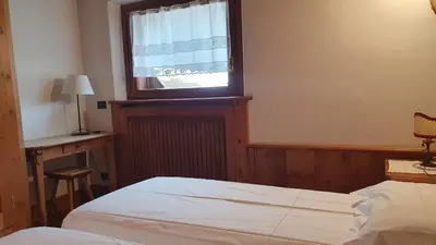 a bedroom with a bed and a window at Chalet Alba in Cortina dʼAmpezzo