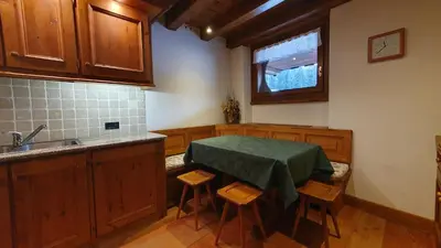 a kitchen with a table and chairs and a sink at Chalet Alba in Cortina dʼAmpezzo