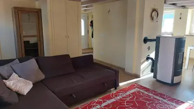 a living room with a brown couch and a tv at Casa Mia in Agordo
