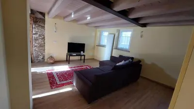 a living room with a couch and a television at Casa Mia in Agordo