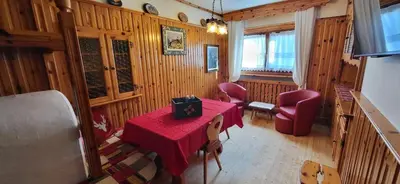 a dining room with a red table and chairs at Lisa & Fufi's Dolomites Home in Cortina dʼAmpezzo