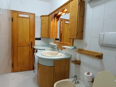 a bathroom with a sink and a toilet and a mirror at Lisa & Fufi's Dolomites Home in Cortina dʼAmpezzo