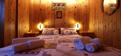 a bedroom with a large bed in a room with wooden walls at Lisa & Fufi's Dolomites Home in Cortina dʼAmpezzo
