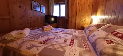 a bedroom with a bed with a christmas quilt on it at Lisa & Fufi's Dolomites Home in Cortina dʼAmpezzo