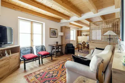 a living room with a couch and a tv at Chalet Lacedel - Dolomiti Skyline in Cortina dʼAmpezzo