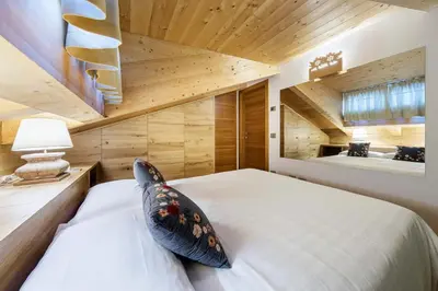 a bedroom with a bed with a pillow on it at Chalet Lacedel - Dolomiti Skyline in Cortina dʼAmpezzo