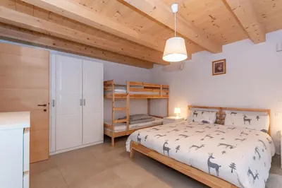 a bedroom with a bed and a wooden ceiling at Ciasa al Caselo in Falcade
