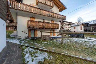 a building with a balcony with snow on the ground at Ciasa al Caselo in Falcade