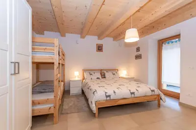 a bedroom with a bunk bed and a ladder at Ciasa al Caselo in Falcade