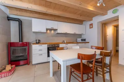 a kitchen with a white table and chairs at Ciasa al Caselo in Falcade