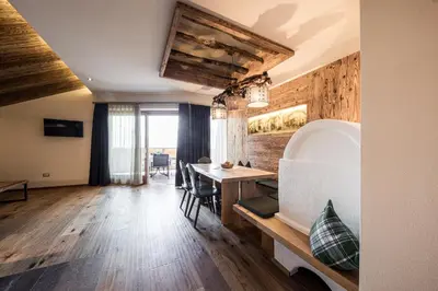 a living room with a table and a dining room at Torgglerhof in Schenna