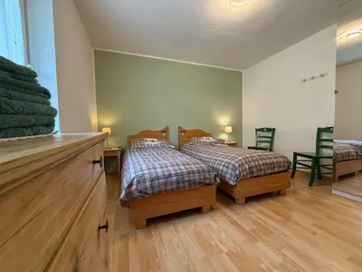 a bedroom with two beds and a window at Mountain Breeze in Castello di Fiemme
