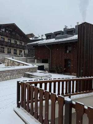 a bedroom with a large bed and a wooden floor at Casa PAOLINA OLIMPIC 2026 in San Vito di Cadore