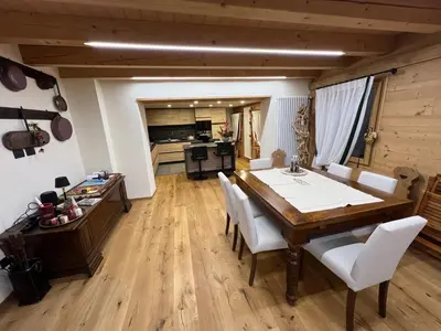 a patio with a retaining wall and a fence at Casa PAOLINA OLIMPIC 2026 in San Vito di Cadore
