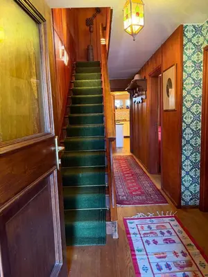 a stairway in a home with green stairs and a rug at Casa panoramica con terrazza vista Tofane in Cortina dʼAmpezzo