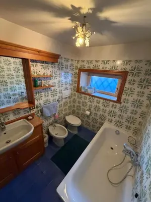 a bathroom with a tub and a toilet and a sink at Casa panoramica con terrazza vista Tofane in Cortina dʼAmpezzo