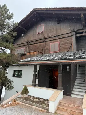 a wooden house with red windows on it at Casa panoramica con terrazza vista Tofane in Cortina dʼAmpezzo